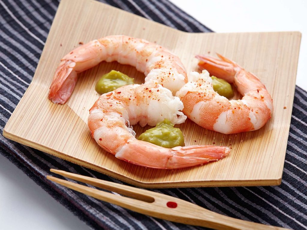 Shrimps on wooden plate and fork